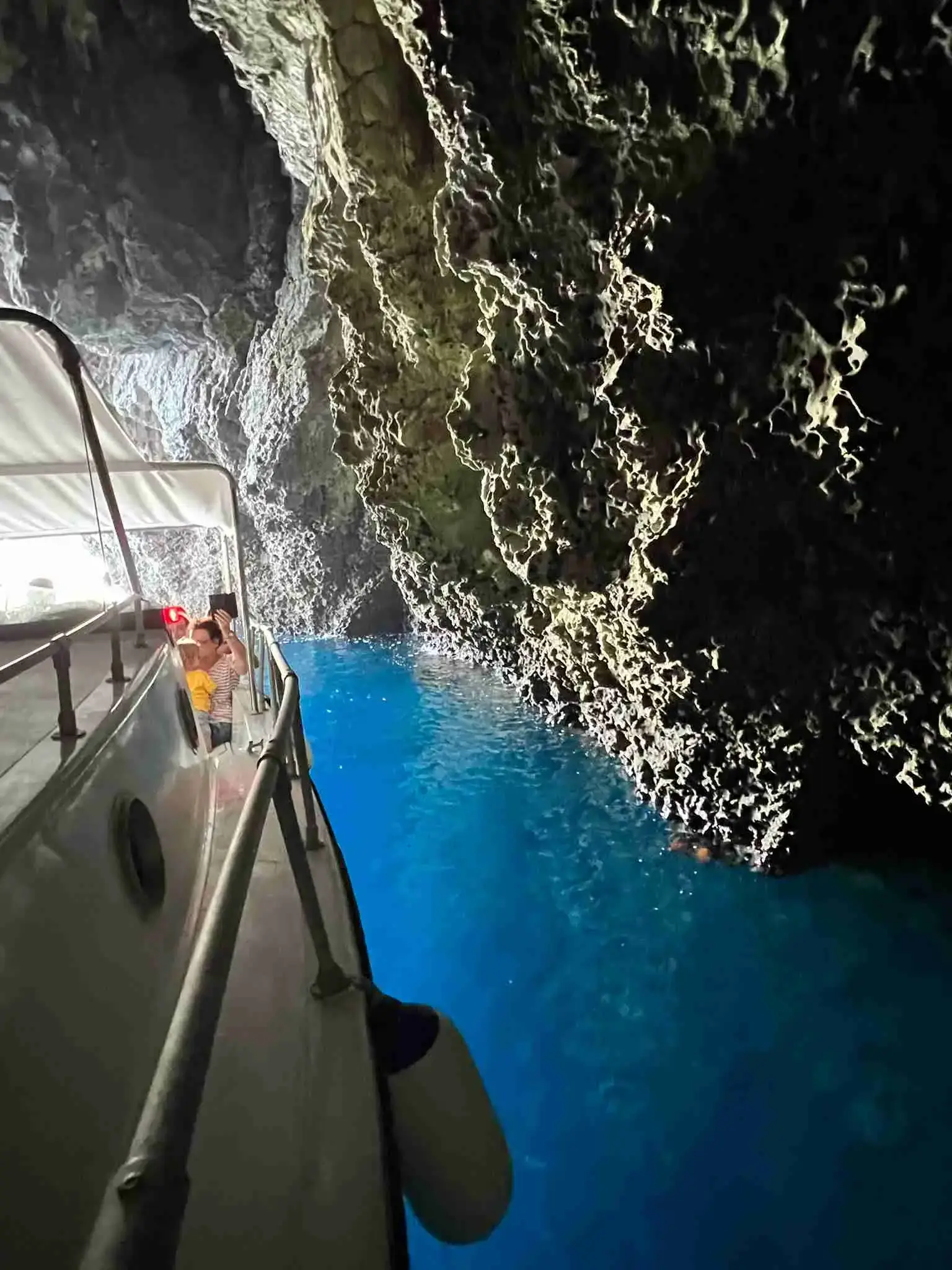 The boat entering a sea cave with deep blue water