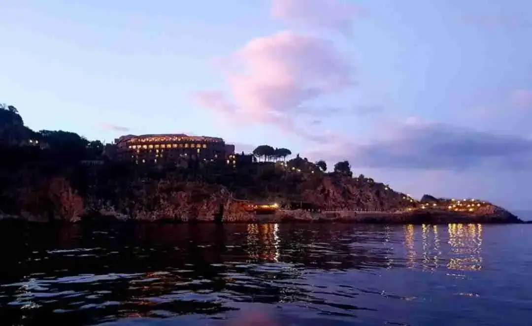 Dusk over Capo Taormina with the lights of the coast
