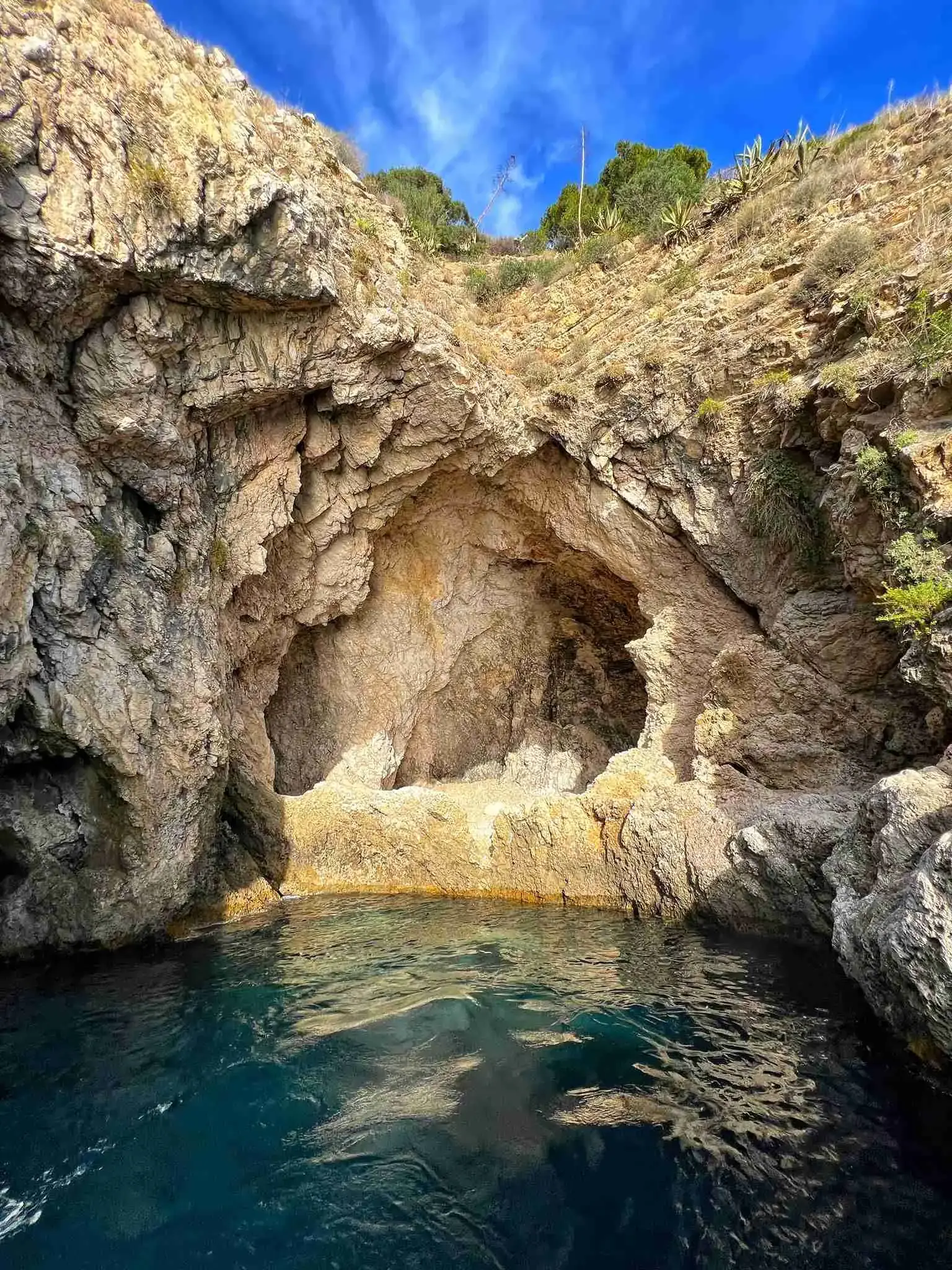 Rock cave under the cliffs of Taormina with clear water